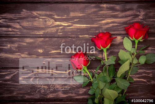 تصویر استوک گل های رز روی پس زمینه چوبی